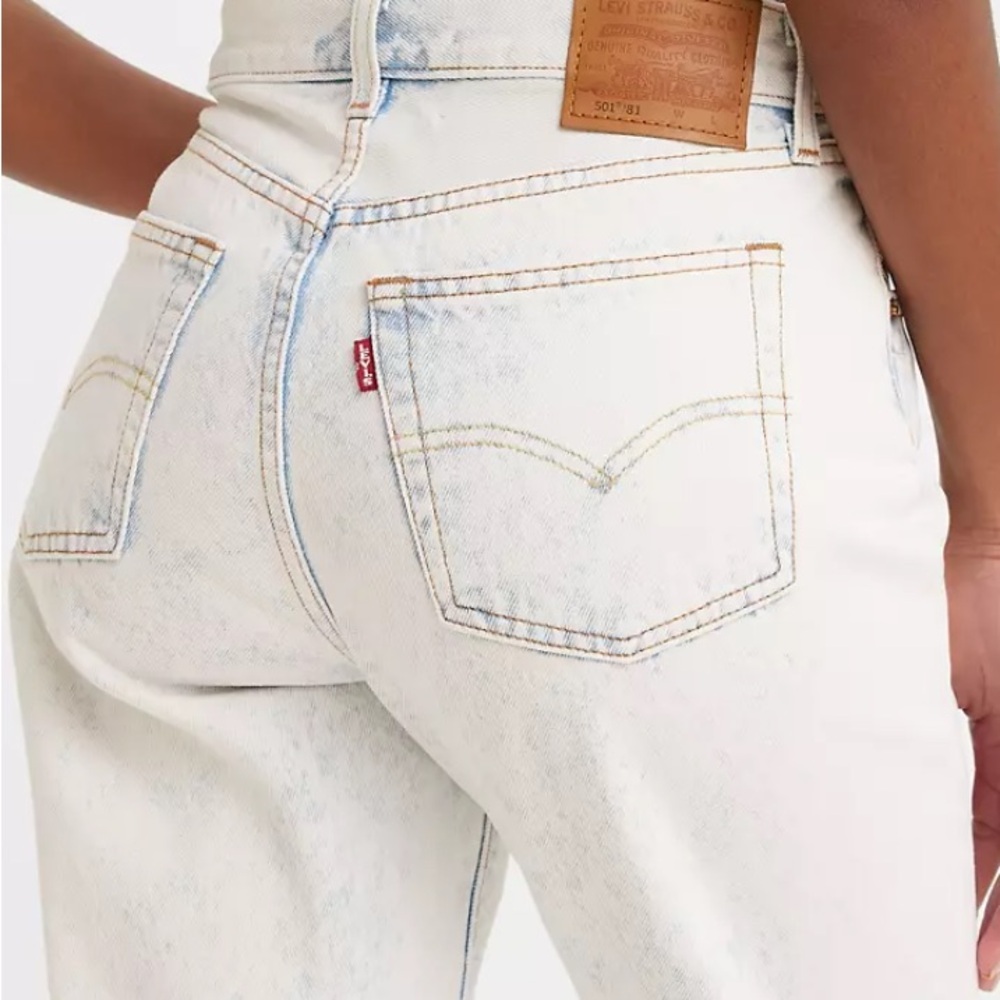 Light wash 501 jeans with acid wash details around seams